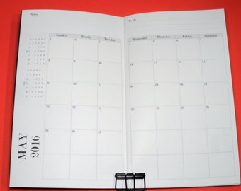 May include: A blank monthly calendar planner for May 2016. The calendar has a notes section on the left page and a to-do list section on the right page. The calendar is divided into days of the week, with each day having a blank space for writing.