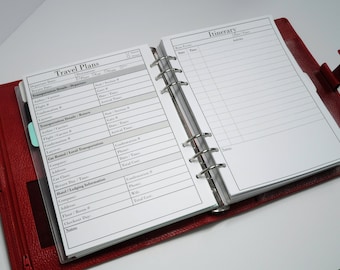 May include: A red leather bound planner with a white page open to a travel planning section. The page has sections for travel plans, transportation details, car rental, hotel lodging information, and an itinerary.