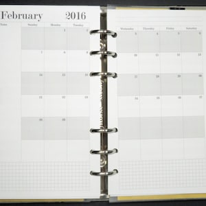 May include: A white monthly planner with a gray grid pattern. The planner is open to February 2016. The planner has a silver binding with six rings.