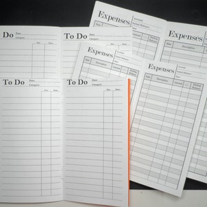 May include: A set of six blank notebooks, four labeled "Expenses" and two labeled "To Do". The notebooks are white with black lines and headings.