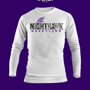 May include: White long-sleeve shirt with the text "Nighthawk Wrestling" in black and purple. The shirt features a graphic of a stylized feather. The brand logo "A New Merch" is at the top.