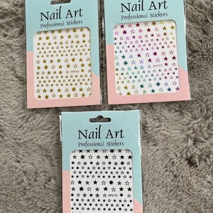 May include: Three packs of nail art stickers featuring different coloured stars. The stickers are on a white background with the text "Nail Art Professional Stickers" and the product code "DP3173".