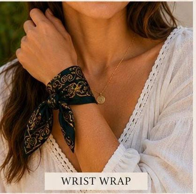 May include: A dark green wrist wrap with a gold paisley design is tied around a wrist. A gold necklace with a pendant is also visible. The text "WRIST WRAP" is displayed in a white rectangle at the bottom of the image.