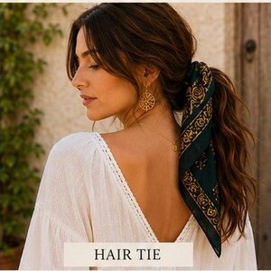 May include: A woman with long brown hair styled in a ponytail, secured with a dark green and gold patterned hair tie. She wears a white top and gold earrings. The text "HAIR TIE" is at the bottom.