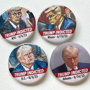 May include: Four round buttons with a cartoon image of Donald Trump on each. Each button has the text "TRUMP INDICTED" with the city and date of the indictment. The cities are NYC, Miami, D.C., and Atlanta.