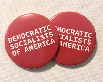 May include: Two red round buttons with white text. The text on the buttons reads "Democratic Socialists of America".
