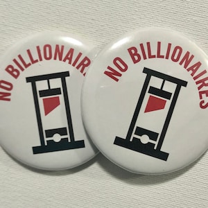 May include: Two white round buttons with the text "NO BILLIONAIRES" in red and black lettering. The buttons feature a black silhouette of a guillotine with a red blade.