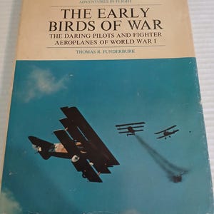 May include: A vintage book cover titled "The Early Birds of War" with a blue and tan color scheme. The cover features illustrations of World War I fighter planes in flight against a blue sky. The book's author is Thomas R. Funderburk.