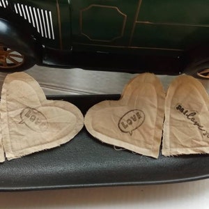 May include: Three heart-shaped fabric patches with the words "I love you", "Love", and "I love you" written on them. The patches are on a black oval-shaped tray.