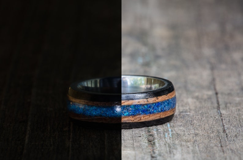 May include: A black and brown wooden ring with a blue inlay. The ring is made of wood and has a silver band.