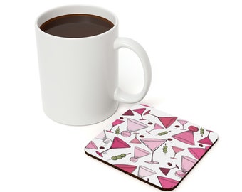 May include: White ceramic coffee mug with a coaster featuring a pink and white pattern of martini glasses with olives and cherries.