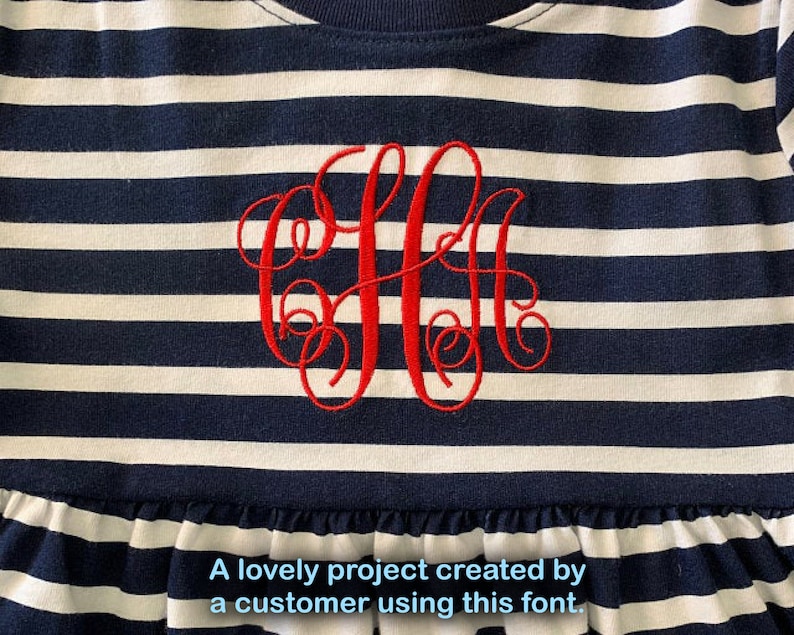 K&ouml;nnte beinhalten: Ein wei&szlig;-blau gestreiftes Kleid mit einem roten gestickten Monogramm. Das Kleid hat einen R&uuml;schen-Saum.