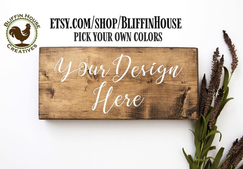 Puede incluir: Un letrero de madera con el texto "Your Design Here" en pintura blanca. El letrero est&aacute; hecho de madera natural con una mancha marr&oacute;n. El letrero es perfecto para agregar un toque personalizado a cualquier hogar u oficina.