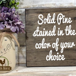 May include: A wooden sign with the text "Solid Pine stained in the color of your choice" in white lettering on a brown background.