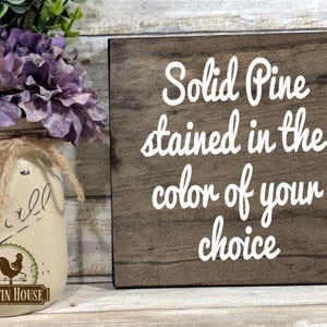 May include: A wooden sign with the text "Solid Pine stained in the color of your choice" in white lettering on a brown background.