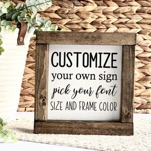 May include: A square wooden sign with a dark brown frame. The white center features black text that reads "CUSTOMIZE your own sign pick your font SIZE AND FRAME COLOR."