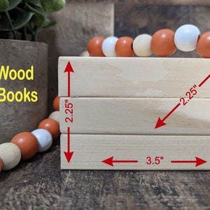 May include: Three stacked wooden blocks, each measuring 2.25 inches by 3.5 inches, with the text "Mini Wood Faux Books" printed on the left side.