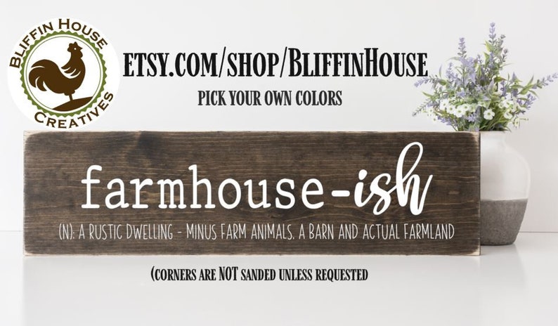 以下が含まれることがあります： 「farmhouse-ish」という文字が白く塗られた素朴な木製の看板。看板には「(N). A rustic dwelling - minus farm animals, a barn and actual farmland」と「(corners are not sanded unless requested」という文字も書かれている。