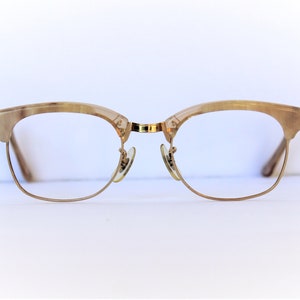 May include: A pair of gold-rimmed glasses with tortoiseshell frames.