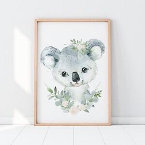 May include: A watercolour painting of a koala bear with a floral wreath around its head. The koala is grey and has a pink nose and mouth. The flowers in the wreath are white and pink.