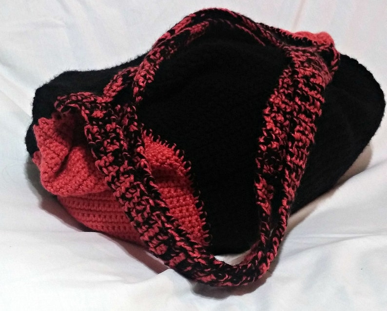 May include: A black and red crocheted tote bag with a single strap.