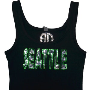 May include: Black tank top with a green and silver rhinestone design that says "SEATTLE".