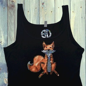 May include: Black tank top with a sparkly orange fox design. The text "By @Blingdots" is printed on the bottom of the shirt.