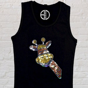 May include: Black tank top with a rhinestone giraffe design. The giraffe is brown, yellow, and gold. The tank top has the text "By @Blingdots" at the bottom.