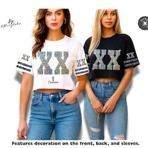 May include: Two cropped t-shirts, one white and one black, each featuring a large, shimmering "XX" design on the front. The white shirt has the word "Custom" below the design. Both shirts have decorative stripes on the sleeves.