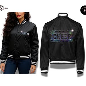 May include: A black varsity jacket with white striped ribbed trim on the collar, cuffs, and hem. The front features the word Custom in silver rhinestones. The back displays the word CHEER in large letters surrounded by a field of colorful rhinestones.