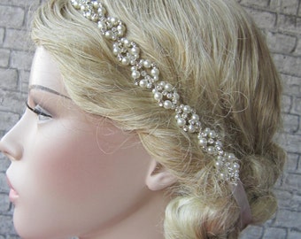 May include: A white pearl and rhinestone headband for a wedding or special occasion. The headband is made of a delicate chain with small pearls and rhinestones.