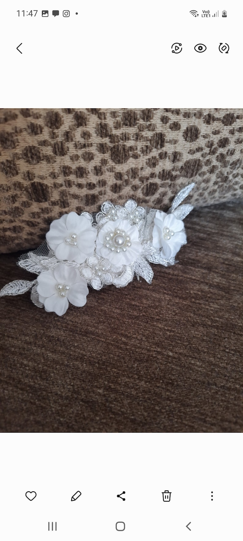 May include: White floral lace applique with pearl embellishments. The applique features three white flowers with pearl centers and delicate lace details.