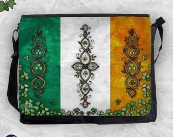 May include: A black messenger bag featuring a printed design of the Irish flag with a green, white, and orange vertical tricolor. The surface is decorated with intricate brown vine patterns and scattered green shamrock illustrations throughout.