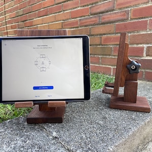 May include: Two wooden tablet stands, one with a black knob and the other with a tablet displaying a screen with the text "Start a Meeting" and a graphic of four video screens in a circle.