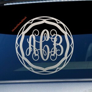 May include: A silver glitter monogram decal with the letters ACB in a decorative circle frame. The decal is on a car window.
