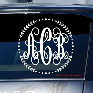 May include: White monogram decal with the letters A, C, and B in a circle with a wreath and dotted border. The decal is on a black car window. The text "WindowFilmAndDecals" is visible in the bottom right corner of the image.