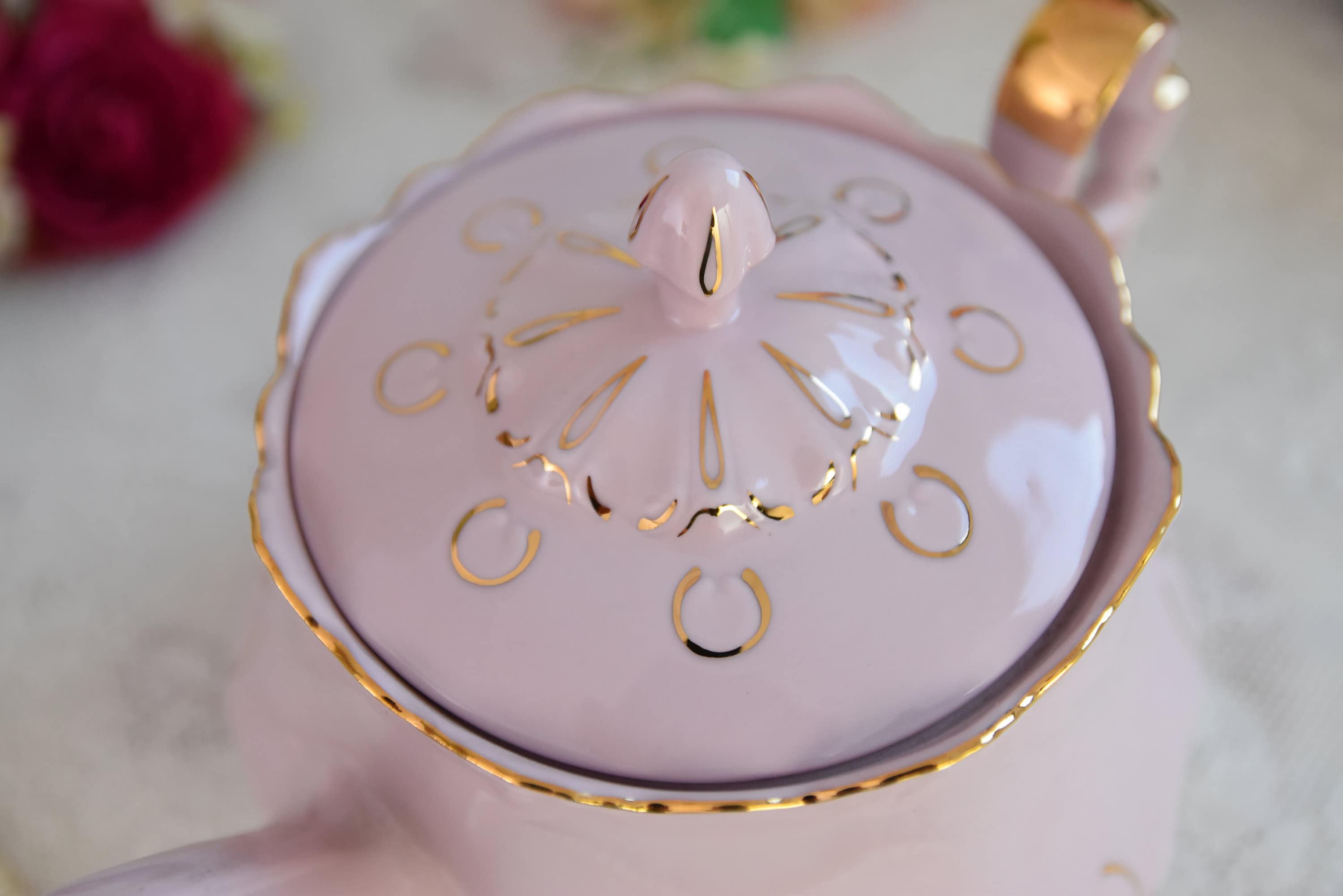 ゴールドのディテールとブルーの花柄のアクセントが入ったピンクの磁器 