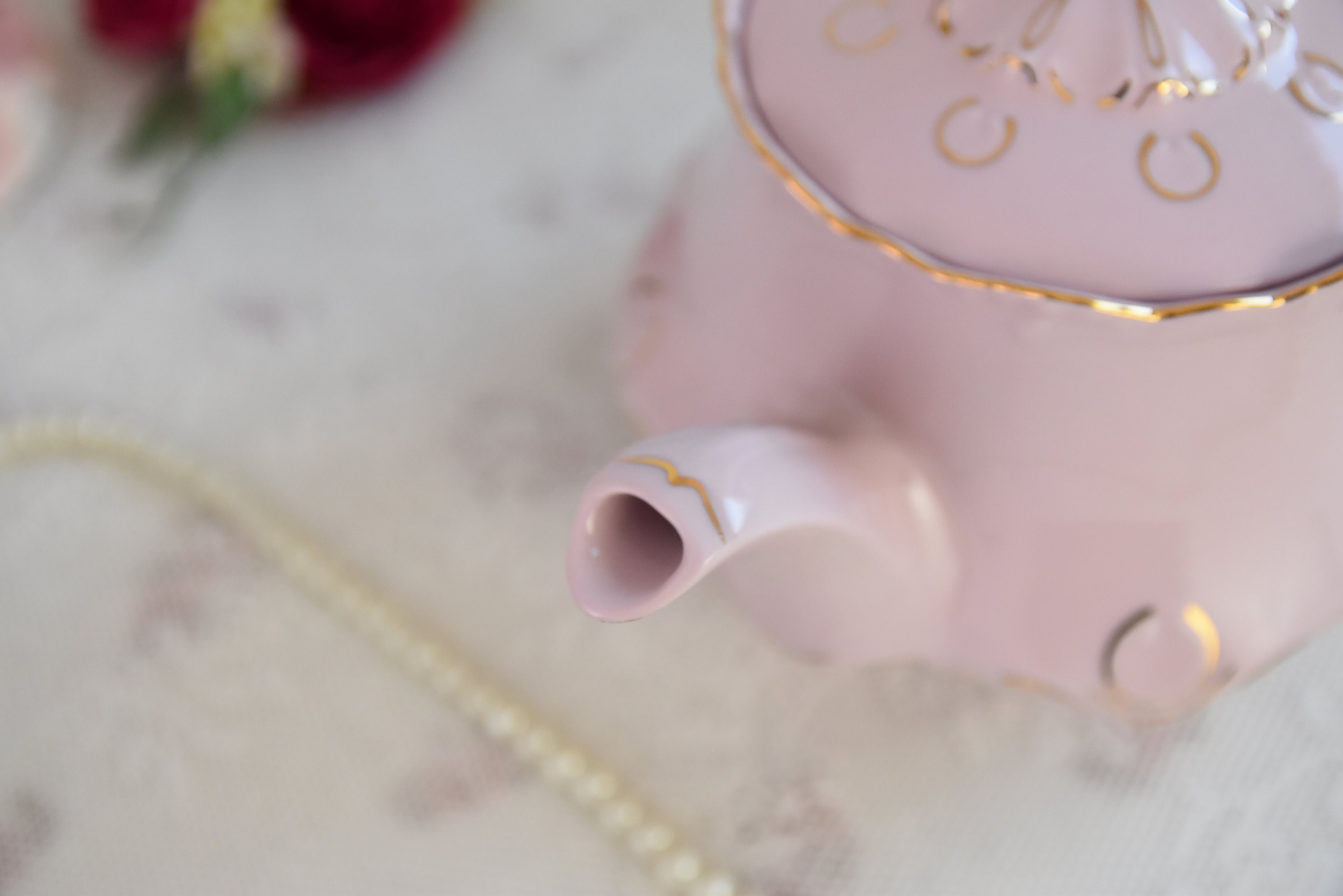 ゴールドのディテールとブルーの花柄のアクセントが入ったピンクの磁器 