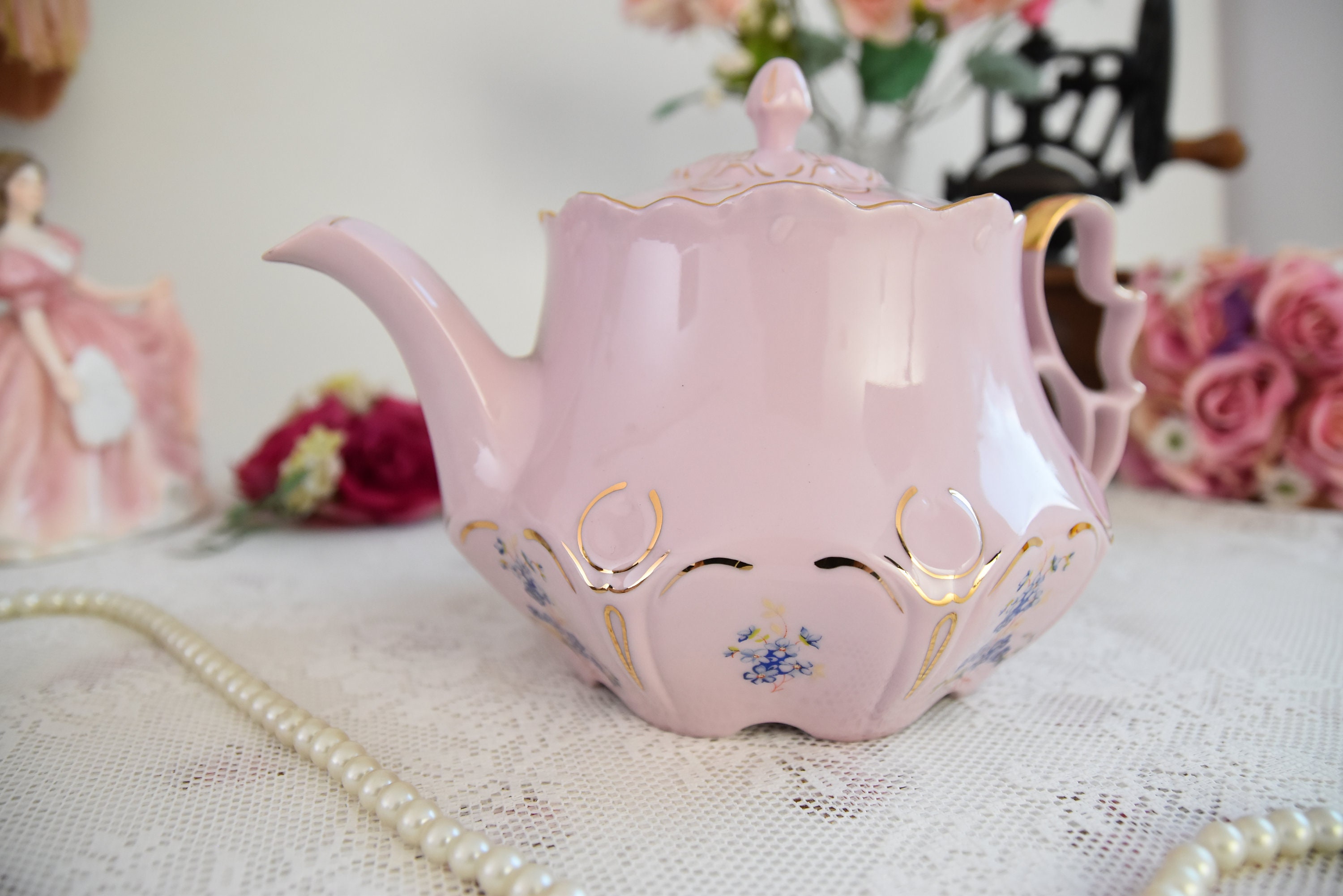 ゴールドのディテールとブルーの花柄のアクセントが入ったピンクの磁器 