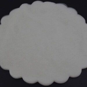 May include: A white, scalloped, round, tissue paper doily.