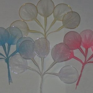 May include: A set of 15 decorative mesh flower accents in white, blue, and pink. The accents are made of a delicate mesh material and have a circular shape. They are attached to thin wires, creating a delicate and airy look.