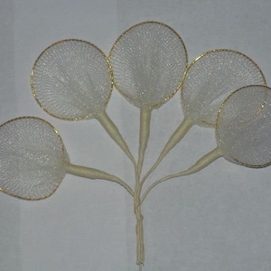 May include: Five white tulle flower accents with gold wire rims. The tulle is gathered at the centre of each accent and attached to a white stem.