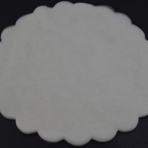 May include: A white, scalloped, round tulle fabric circle.
