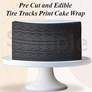 May include: A cake with a tire track design on a white cake stand. The cake wrap is black and gray, with the text "Pre Cut and Edible Tire Tracks Print Cake Wrap" at the top.