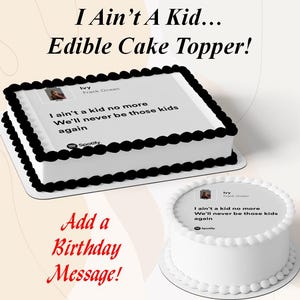 May include: Two white cakes with black and white frosting. The rectangular cake has black frosting around the edges. The text on the cakes reads "I Ain't A Kid... Edible Cake Topper!" and lyrics from Frank Ocean's song "Ivy".