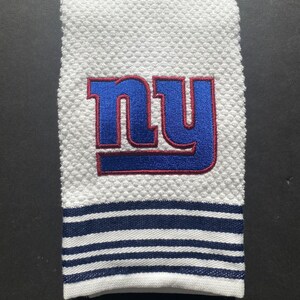 May include: White kitchen towel with a blue and red embroidered "NY" logo and a navy blue and white striped border.