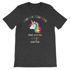May include: Dark grey t-shirt with a rainbow unicorn graphic and the text "Unicorn Teachers Make A Little Magic Every Day".