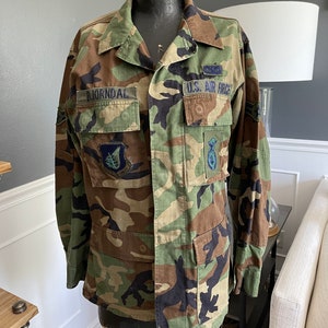 Könnte beinhalten: Eine Tarnjacke mit einem Namensschild mit der Aufschrift "BJORNDAL" und einem Aufnäher mit der Aufschrift "U.S. AIR FORCE".