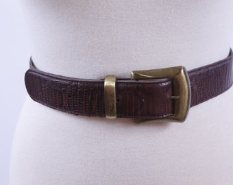 May include: A brown leather belt with a textured, embossed pattern and a gold-toned buckle.