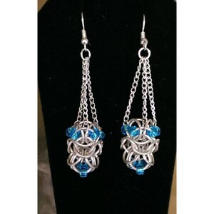 May include: Silver dangle earrings with a blue crystal bead cluster at the bottom of each earring.